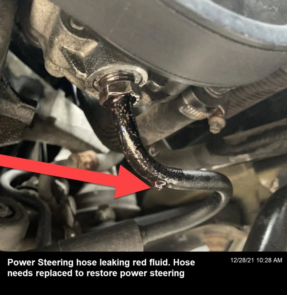 Power steering fluid leak with a red color, causing the power steering system to lose effectiveness and resulting in a rigid steering wheel