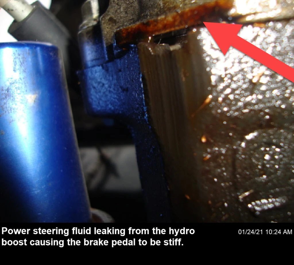 A power steering fluid leak from the hydro boost results in a stiffer brake pedal
